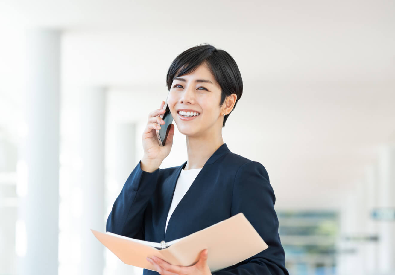 スーツを着用した女性が電話中の様子
